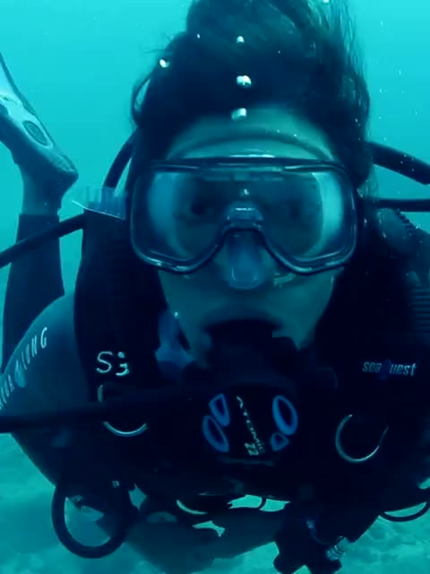 Scuba diver swimming in blue water